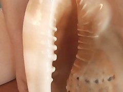 Crazy Alice enjoys using a sea shell on her pussy
